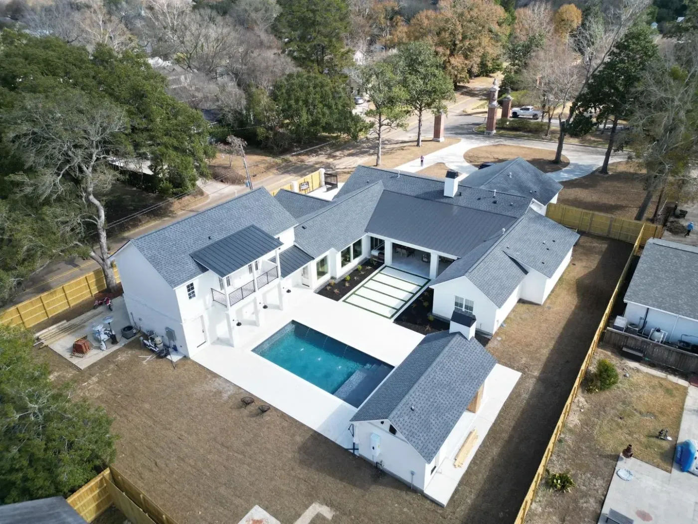 Aerial view of a Puebla Construction white modern home with a courtyard pool