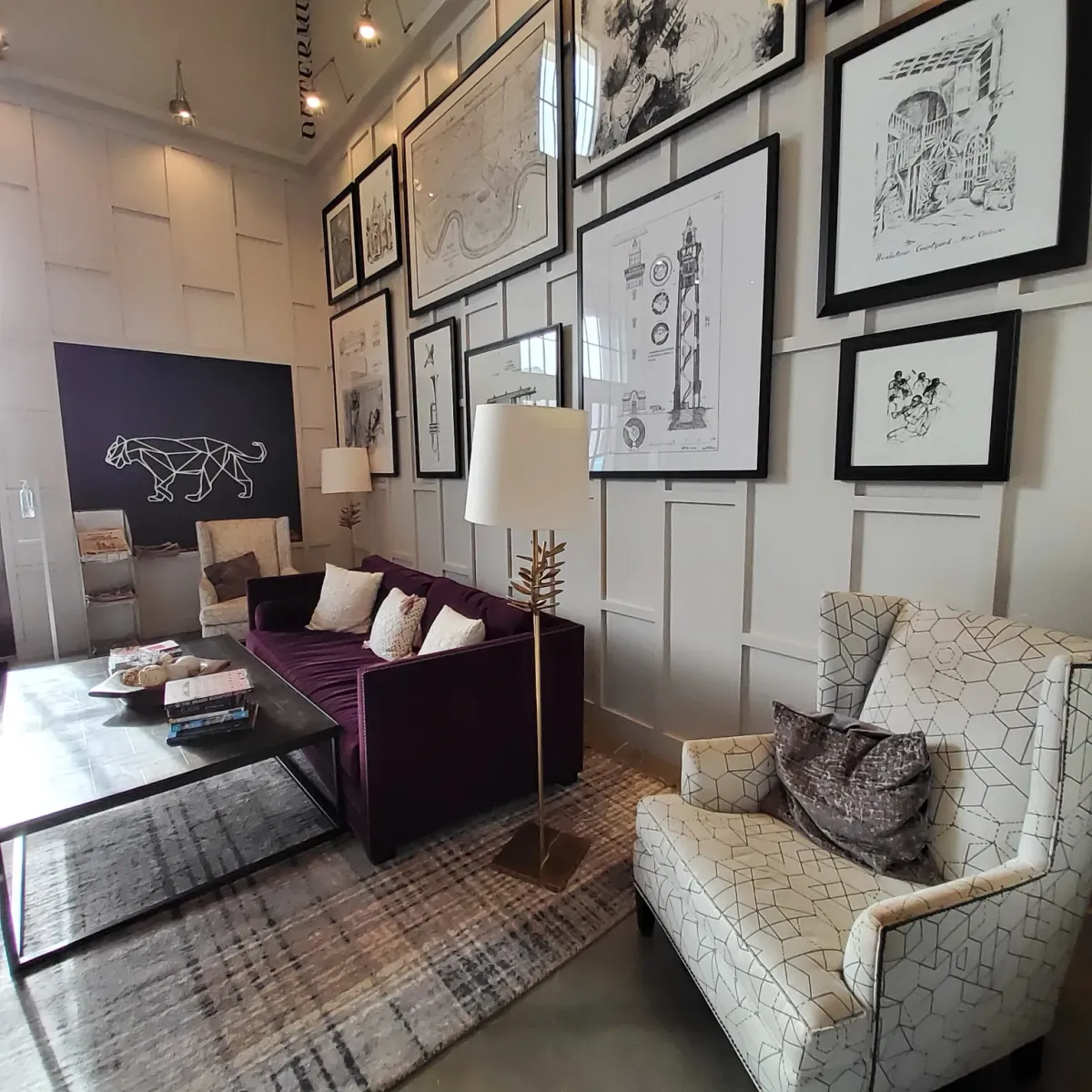 Panel-wall living room with framed architectural prints and the Puebla panther mark