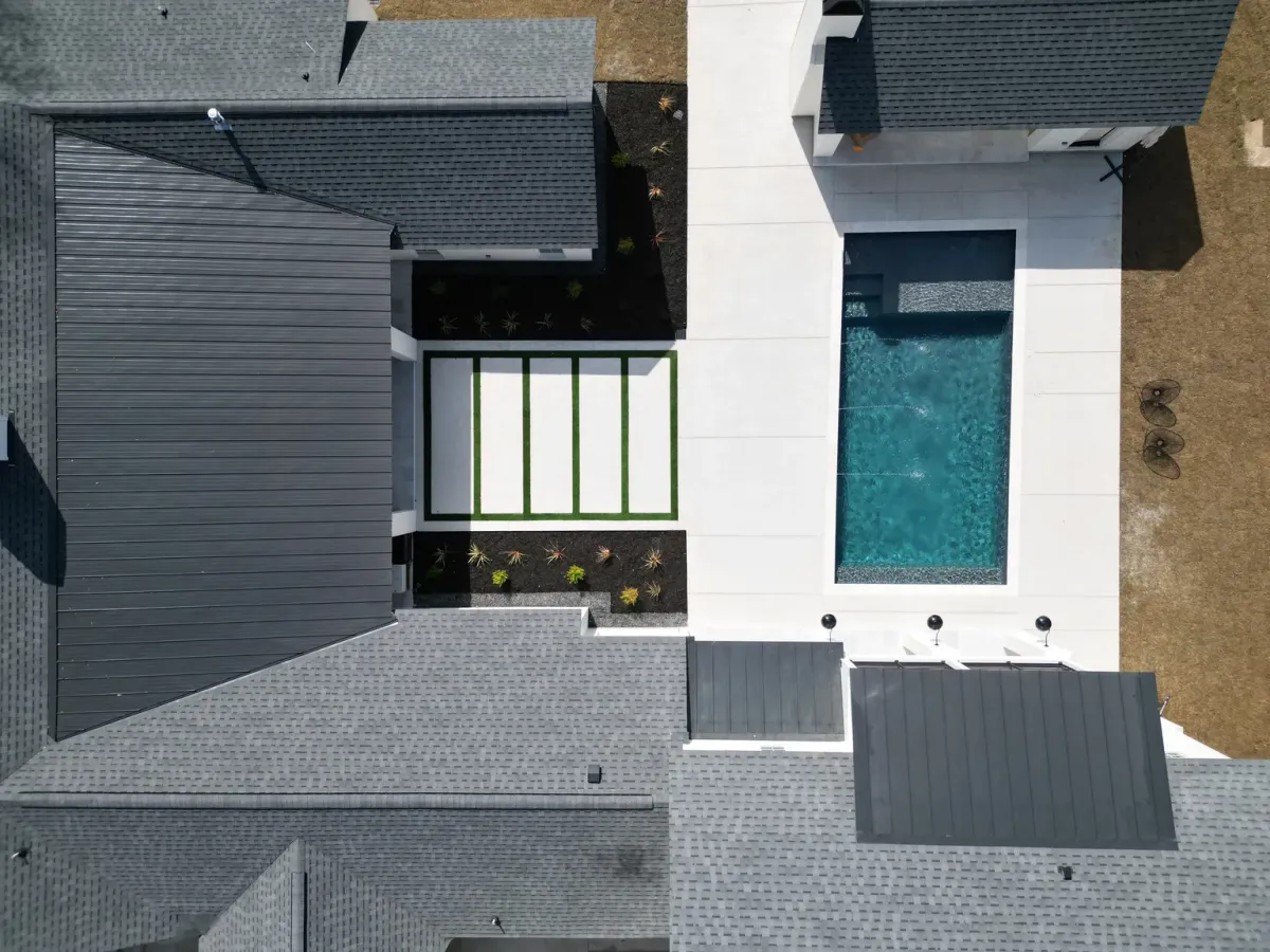 Top-down aerial of a modern pool and turf courtyard